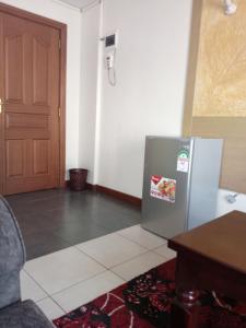 a kitchen with a refrigerator and a wooden door at Best suites Mvuli in Nairobi