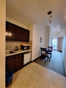 a kitchen with a sink and a table with chairs at Times Square Service Apartment , Kuala Lumpur in Kuala Lumpur