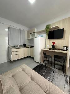 cocina con nevera blanca y mesa con sillas en Flamingo Pé na Areia Economico, en Matinhos