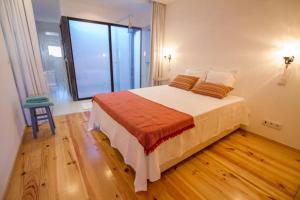 - une chambre avec un grand lit et une grande fenêtre dans l'établissement Casa dos Mercanteis, à Aveiro