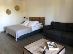 una piccola camera da letto con un letto e un divano di Le Mayann a Le Diamant Altre 14 foto