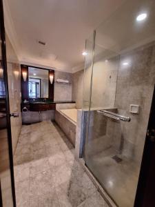 uma casa de banho com um chuveiro, uma banheira e um lavatório. em Times Square Service Apartment , Kuala Lumpur em Kuala Lumpur