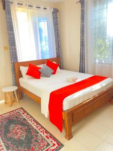 a bedroom with a large bed with red pillows at MASKANI COSY APARTMENT - Nyali, Mombasa. in Mombasa