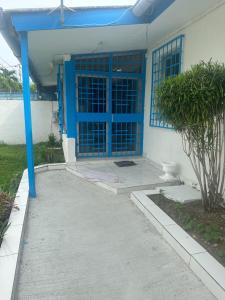 a house with a blue door and a sidewalk at Villa bord de mer louis in Libreville