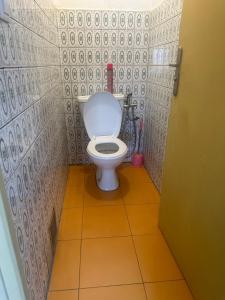 a bathroom with a toilet in a tiled room at Villa bord de mer louis in Libreville