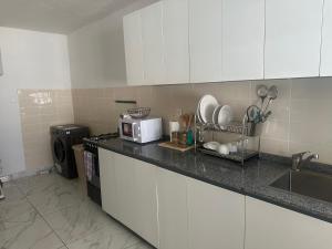 eine Küche mit einer Arbeitsplatte und einer Mikrowelle in der Unterkunft Villa bord de mer louis in Libreville