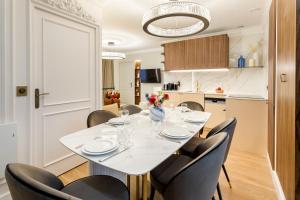 comedor con mesa blanca y sillas en Luxury 2 Bedroom & 2 Bathroom Suite - Marais en París