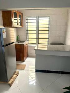uma cozinha com um frigorífico de aço inoxidável e armários de madeira em kaya homes em Dar es Salaam