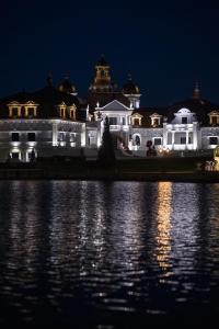 a large white building at night next to a body of water at Edem Resort Medical & SPA in Strelki +200 photos