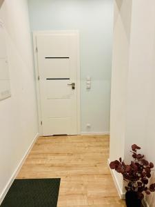 a hallway with a white door and a plant at Apartment Targowa L8 in Lublin
