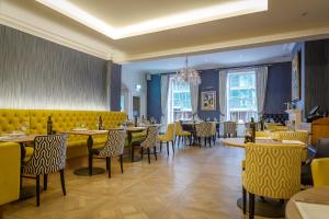 a restaurant with tables and chairs and a chandelier at Harbour Hotel & Spa Chichester in Chichester