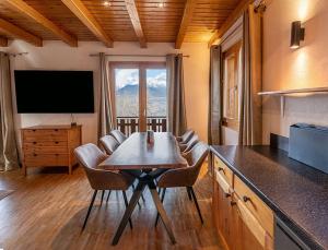 a dining room with a table and chairs and a television at Grand Chalet Veysonnaz w/Spa in Sion