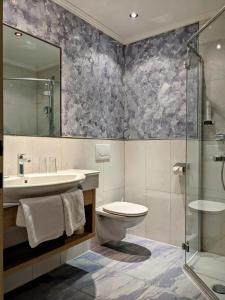 W łazience znajduje się toaleta, umywalka i prysznic. w obiekcie Hotel Bräu w mieście Rauris