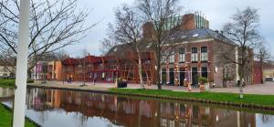 a building next to a river in front of a building at Top Bed and Breakfast in Sneek