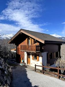 a wooden house with a fence in front of it at Grand Chalet Veysonnaz w/Spa in Sion