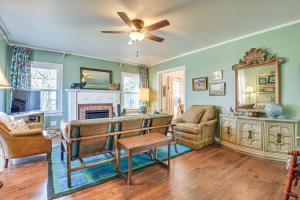 a living room with green walls and a ceiling fan at Quiet Fort Worth Home Less Than 1 Mi to TCU Campus! in Fort Worth