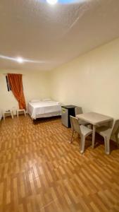 a room with a bed and a desk and a table at Paraíso de Rojas hotel in Santa Bárbara de Samaná