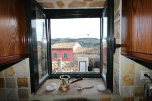 ventana en la cocina con vistas a un edificio en Corfu Ariandi Stone House en Giannádes