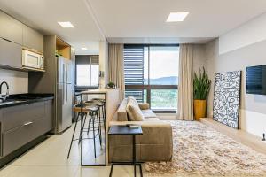 uma sala de estar com um sofá e uma cozinha em Apto incrível em Jurere Internacional - SRE505 em Florianópolis