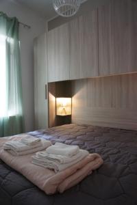 una camera da letto con un letto con asciugamani sopra di O lastraco a Trapani