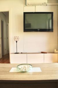a glass bowl on a table with a tv on the wall at Gran Vía-Plaza España 2 habitaciones in Madrid