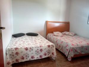 dwa łóżka w małym pokoju z dwoma łóżkami w obiekcie Chales Horizonte das Pedras w mieście São Thomé das Letras