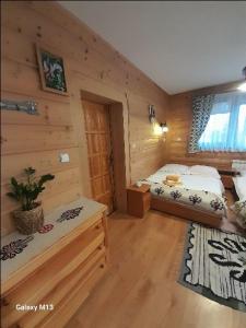 a bedroom with two beds in a log cabin at Pokoje Gościnne Centrum Nowotarska in Zakopane