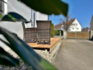 duas cadeiras sentadas num deque de madeira numa casa em JIRVISTA-Homes, frisch renoviert, voll ausgestattete Wohnung im EG, kontaktloser Zutritt em Burghausen