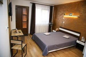 a bedroom with a bed and a table and a window at House Garden in Turda