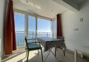 - stół i krzesła w pokoju z balkonem w obiekcie BEACH PALACE CB08 w mieście Platja  d'Aro