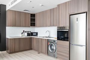 a kitchen with a refrigerator and a washing machine at Silkhaus High Floor 1BDR in Iconic DIFC Tower in Dubai
