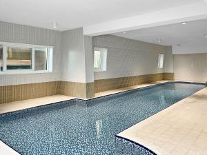 a large swimming pool in a room with a tile floor at Silkhaus High Floor 1BDR in Iconic DIFC Tower in Dubai