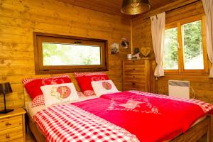 una camera con letto rosso in una baita di tronchi di Almliesl STEF-633 a Sankt Stefan im Lavanttal