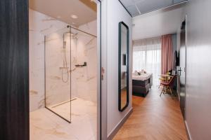 a bathroom with a shower with a glass door at Hotel Keur in Zandvoort