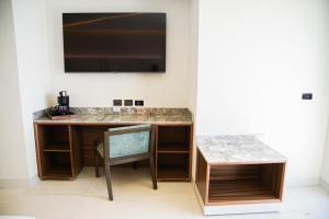 瓜達拉哈拉的住宿－Hotel Antré，墙上有电视的房间里一张桌子
