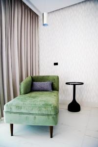 瓜達拉哈拉的住宿－Hotel Antré，客厅配有一张绿椅和一张桌子