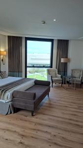 a bedroom with a large bed and a large window at Hotel Bahía in Santander