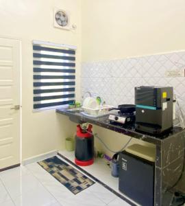 a kitchen with a counter with a computer on it at Az HOMESTAY PENDANG KEDAH in Pendang