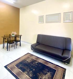 a black leather couch in a living room with a table at Az HOMESTAY PENDANG KEDAH in Pendang
