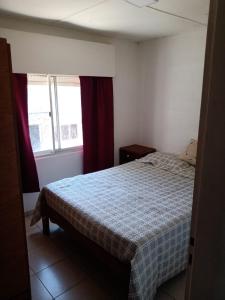 um quarto com uma cama e duas janelas em Depto amoblado em Gualeguaychú