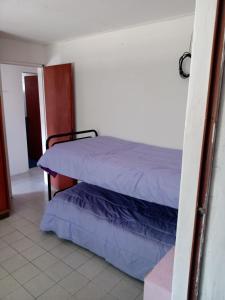 a bedroom with a bed with purple sheets at Depto amoblado in Gualeguaychú