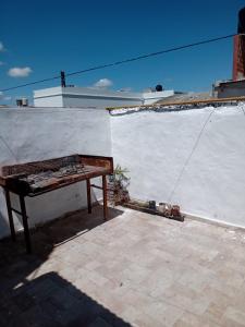 a bench sitting on the side of a white wall at Depto amoblado 3 habitaciones calle 3 de Caballería 463 in Gualeguaychú