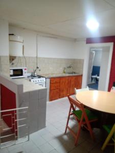 a kitchen with a table and a stove top oven at Depto amoblado 3 habitaciones calle 3 de Caballería 463 in Gualeguaychú