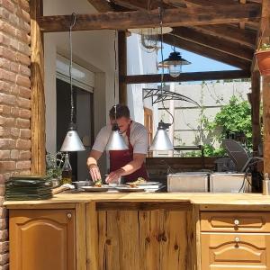 un hombre de pie en una cocina preparando comida en Panská sýpka en Sedlec