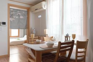 ein Esszimmer mit einem Tisch und Stühlen in einem Zimmer in der Unterkunft Damda Stay in Seoul