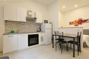 une cuisine avec des armoires blanches et une table et des chaises dans l'établissement Civico116 - Dentro le mura, parcheggio gratuito, à Sienne 16 autres photos