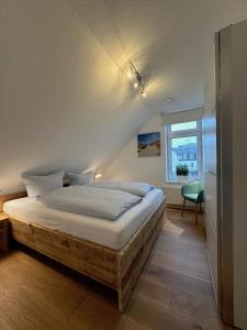 a bedroom with a bed in a room with a window at Georg6 GEORG6 - Fewo 5 in Norderney