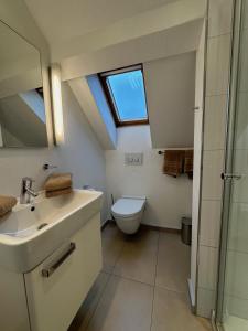 a bathroom with a sink and a toilet with a skylight at Georg6 GEORG6 - Fewo 5 in Norderney