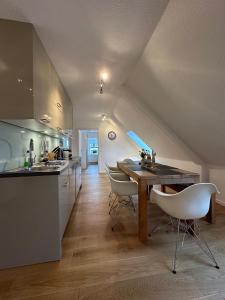 a kitchen with a wooden table and white chairs at Georg6 GEORG6 - Fewo 5 in Norderney