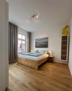een slaapkamer met een groot bed en een raam bij Georg6 GEORG6 - Fewo 4 in Norderney